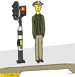 Een lange man bij het stoplicht.