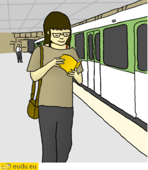Een meisje loopt over het perron van de metrohalte en leest een
			boek.