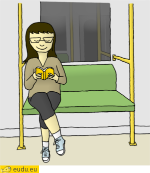 Een meisje zit op een bankje in de metro en leest een
			boek.