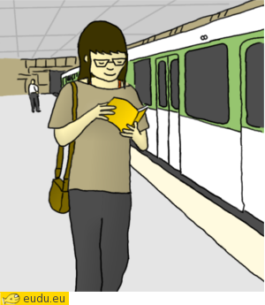 Een meisje loopt over het perron van de metrohalte en leest een boek.